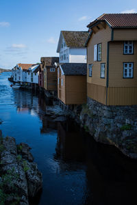 Buildings in sogndalstrand by river against sky