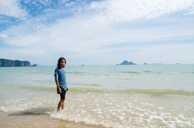 Full length of man standing on beach against sky