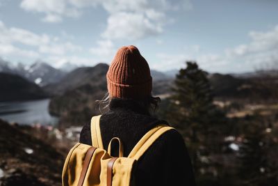 Rear view of woman standing against mountain in winter