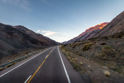 Empty road by mountain against sky