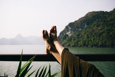 Close-up of hand on mountain against clear sky