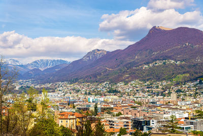 Aerial view of townscape and mountains against sky