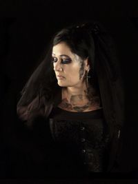 Woman wearing costume against black background