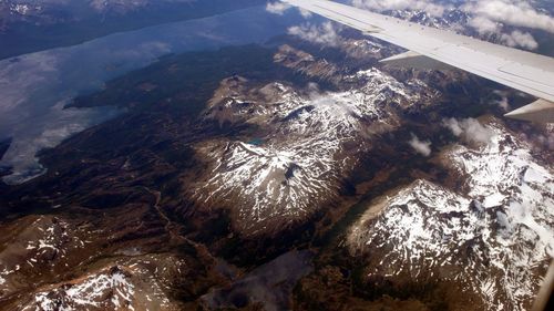 Cropped image of airplane flying over mountain range