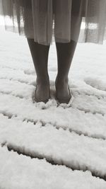 Low section of woman standing on snow