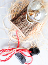 Close-up of light bulb on wood against white background