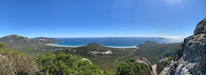 Panoramic view of sea and mountains against blue sky