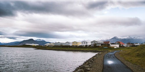 Panoramic view of buildings by mountains against sky