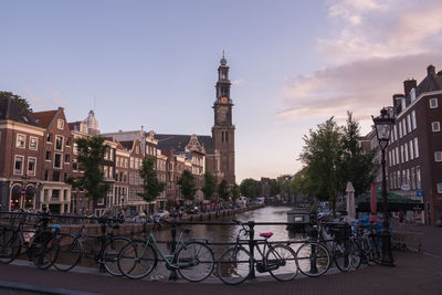 Westerkerk by amstel river in city against sky