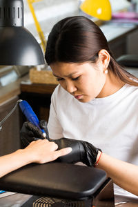 Side view of young woman using laptop at home