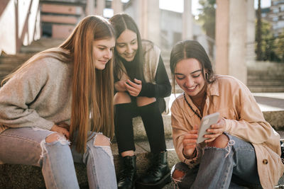 Portrait of smiling young woman using mobile phone