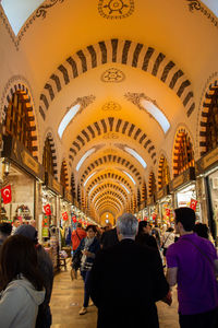 Rear view of people walking in illuminated cathedral