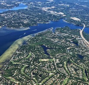 Aerial view of city by river against sky