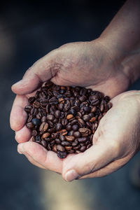 Cropped image of hand holding roasted coffee beans