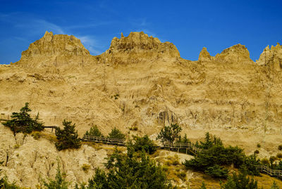 Scenic view of rock formations against blue sky