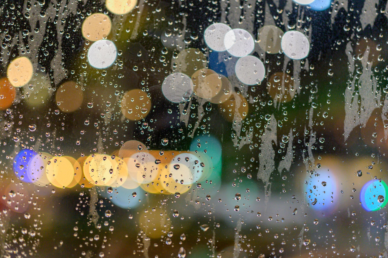 CLOSE-UP OF RAINDROPS ON GLASS WINDOW