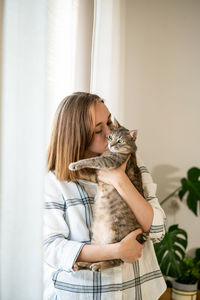Side view of young woman with daughter at home