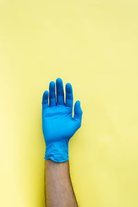 Close-up of hand against blue background