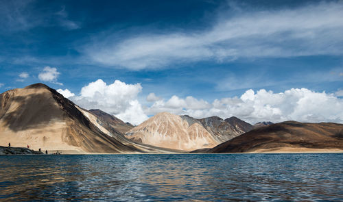 Scenic view of lake by mountains against sky