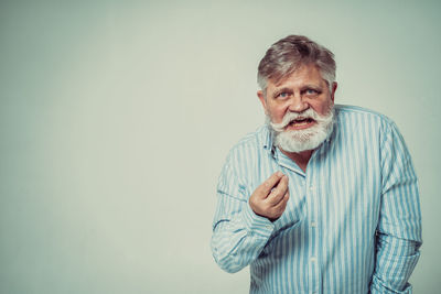 Portrait of man standing against gray background