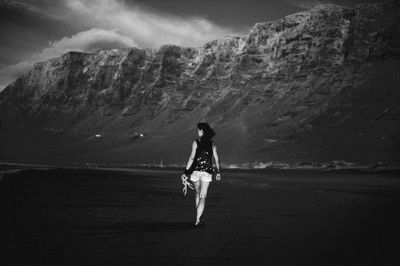 Rear view of woman on sea shore against sky