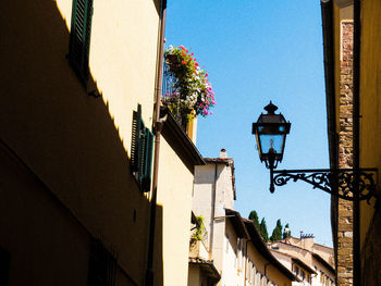 Low angle view of street light by building against sky