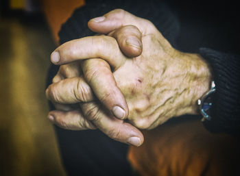 Midsection of senior man with hands clasped