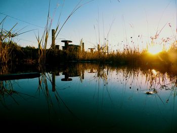 Scenic view of lake against sky at sunset