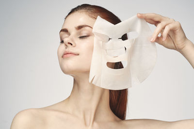 Close-up of beautiful woman removing facial mask