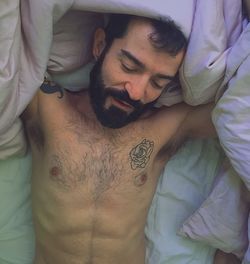 Young man lying on bed