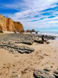 Scenic view of rocks on beach against sky