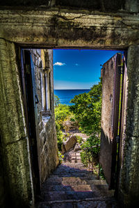 Walkway by sea against sky