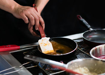 Midsection of person preparing food in kitchen