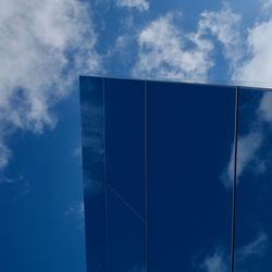 Low angle view of modern building against blue sky