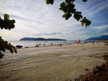 Group of people on beach against sky