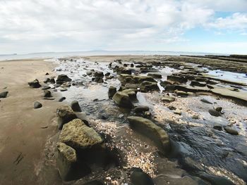 Rocks on beach against sky