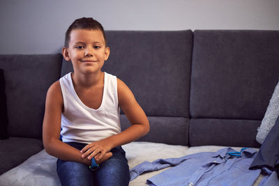 Portrait of boy sitting on sofa at home