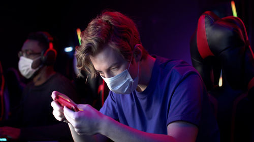 Portrait of mature man using mobile phone at night