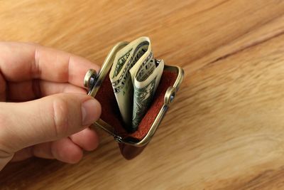 High angle view of person holding eyeglasses on table