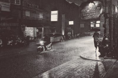 People walking on illuminated street at night