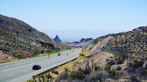 Road amidst mountains against clear sky