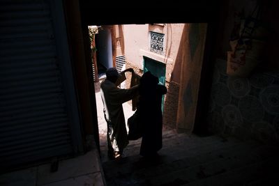 Rear view of people standing at entrance of building
