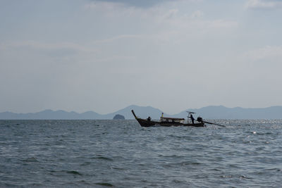 Fishing boat in sea against sky