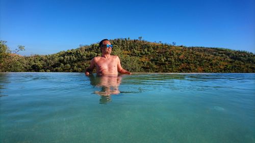 Rear view of shirtless man in water