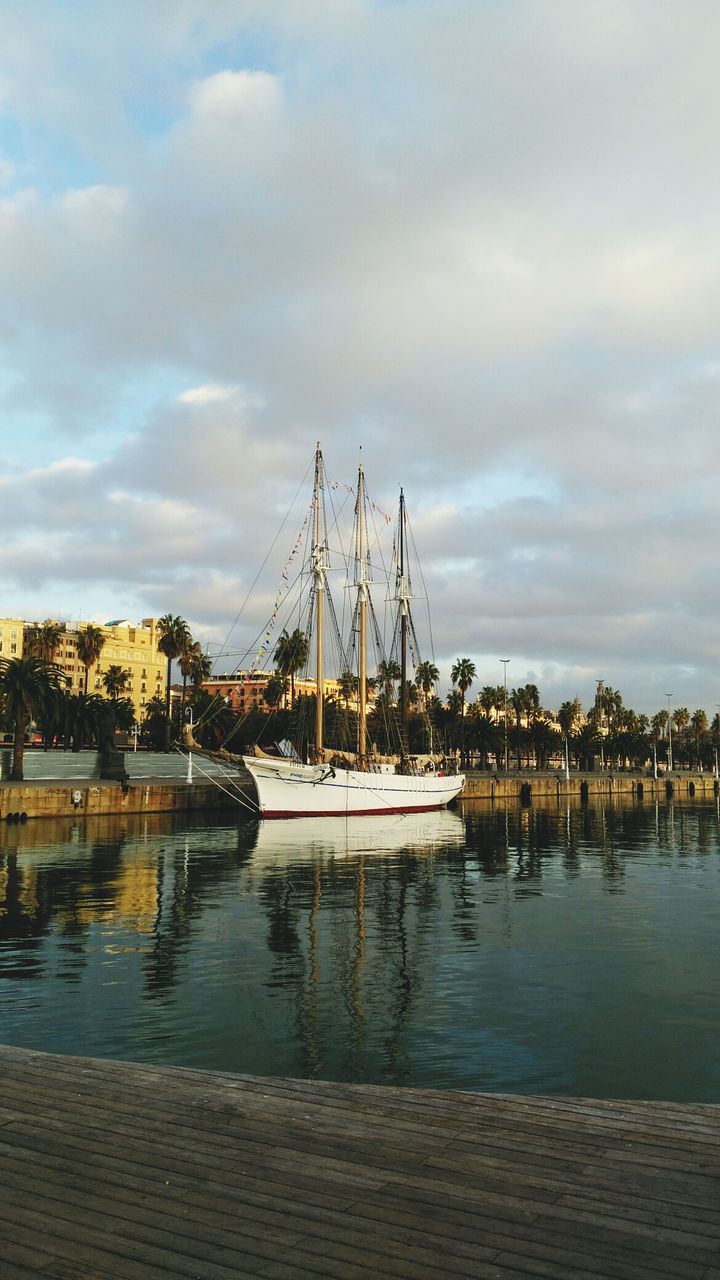 water, nautical vessel, moored, cloud - sky, sky, mast, boat, sailboat, harbor, mode of transport, reflection, transportation, marina, tranquility, outdoors, nature, waterfront, no people, lake, jetty, scenics, day, yacht, beauty in nature, built structure, building exterior, architecture, sailing ship