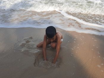 Full length of shirtless man on beach