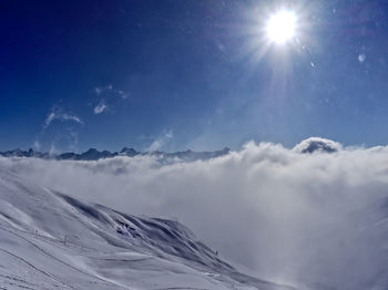 Low angle view of snowcapped mountain against blue sky