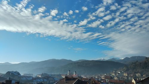 Town by mountains against blue sky