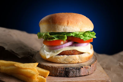 Close-up of burger on table against black background