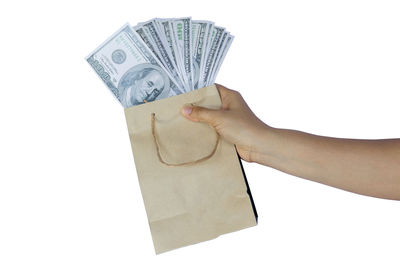 Low angle view of hand holding paper against white background